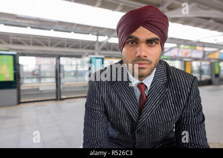 Indian businessman wearing turban et assis à la gare Banque D'Images