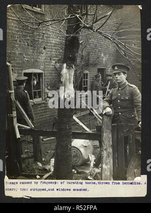 Dommages causés par des fragments d'éclatement des bombes, lancées de zeppelins. Un cerisier dépouillés, et les fenêtres brisées [Angleterre]. Soldats britanniques debout parmi les ruines. Dossier de l'armée indienne en Europe durant la Première Guerre mondiale. 20e siècle, 1915. Argentiques. Source : Photo 24/(28). Langue : Anglais. Auteur : Big Sur, H. D. Banque D'Images