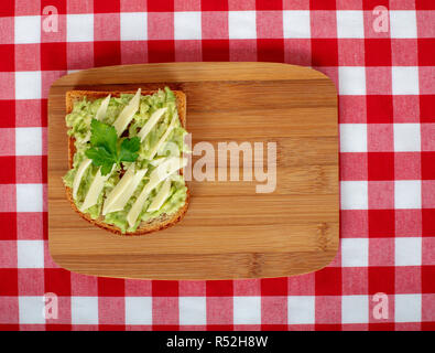 Petit-déjeuner sain sandwich sur du pain grillé avec de l'avocat et fromage sur fond de bois. Télévision jeter dessus. Banque D'Images