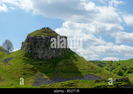 Groupe de gens assis sur rock formation in Derbyshire Peak District en Angleterre Banque D'Images