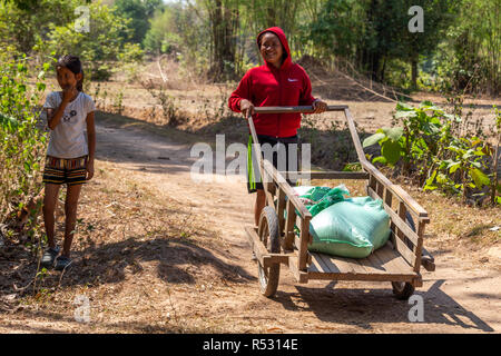 Don Daeng, le Laos - Avril 27, 2018 Local : Mère et fille transportant des produits agricoles sur un panier en bois Banque D'Images