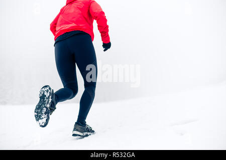 Fille courir sur la neige en hiver les montagnes. Se concentrer sur seul de spectacle avec la neige. Banque D'Images