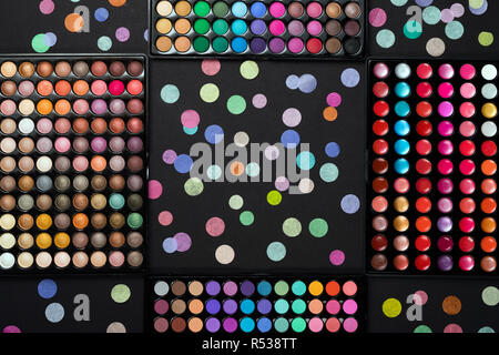 Maquillage cosmétique avec palettes de couleurs dispersées confetti sur fond noir Banque D'Images