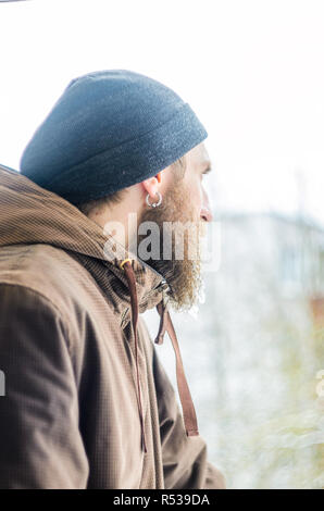 Portrait d'hiver jeune homme de profil. Barbe couverte de glaçons et gouttelettes congelées. Banque D'Images