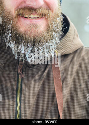 Beard dans les glaçons. Partie du visage d'un jeune homme dans un veston brun. Concept de sports d'hiver à l'air libre. Banque D'Images