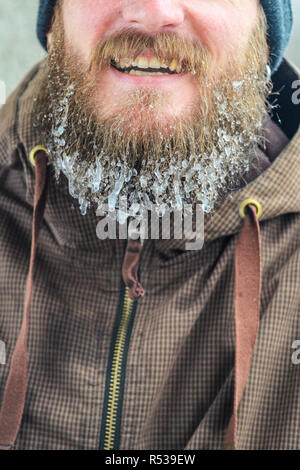 Beard dans les glaçons. Partie du visage d'un jeune homme dans un veston brun. Concept de sports d'hiver à l'air libre. Banque D'Images