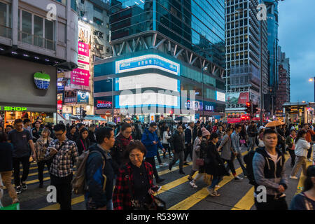 Les personnes qui traversent la rue Nathan à Mong Kok, l'un des plus densément peuplées au monde. Hong Kong, Kowloon, Janvier 2018 Banque D'Images