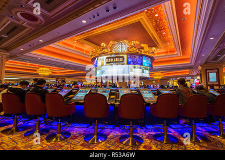 Les gens en jouant au jeu de machines dans le casino Venetian, le plus grand casino du monde et hôtel de luxe. Macao, Janvier 2018 Banque D'Images