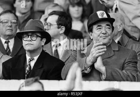 Elton John et Robert Maxwell regardant l'Oxford United v Watford match de football. Score final 1-1. Une Division de la ligue. Elton John avait annoncé jours avant qu'il a été la vente de ses 90  % dans la région de Watford FC holding. 21 novembre 1987. Banque D'Images