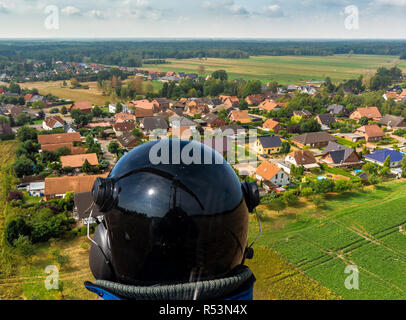 Vue aérienne d'un petit village de la distance derrière un morceau de forêt et un champ d'asperges, couvrir de papier d'aluminium à base de drone Banque D'Images