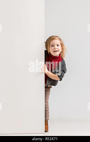 Portrait d'une petite fille surprise et permanent pointant deux doigts loin  à copie espace isolé sur fond blanc Photo Stock - Alamy