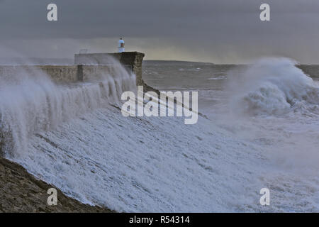 Porthcawl, au Pays de Galles. 29 novembre 2018. Les scènes dramatiques comme des ondes de tempête par Diana, smash sur le brise-lames et phare de port de Porthcawl, dans le sud du Pays de Galles. Banque D'Images