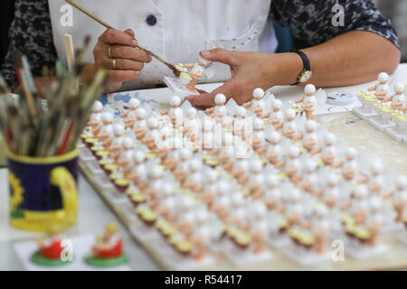 08 novembre 2018, Saxe, Grünhainichen : Un employé de la manufacture Wendt&Kühn peint la figure 'ange avec deux timbales'. La sculpture et la production de jouets en bois sont toujours une branche importante de l'économie dans l'Erzgebirge. La gamme va du classique deux hommes dans les affaires de famille à de grandes entreprises de taille moyenne. Avec près de 200 employés, Wendt&Kühn est l'une des plus grandes entreprises dans l'industrie. Photo : Jan Woitas/dpa-Zentralbild/dpa Banque D'Images