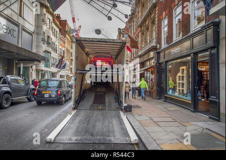 Bonhams, New Bond Street, London, UK. 29 novembre 2018. Véhicules Historiques arrivent à Bonhams au centre de Londres pour la vente de voiture qui aura lieu le 1er décembre 2018. De droit : Les voitures sont déchargés à New Bond Street sous les décorations de Noël et aux côtés des boutiques de designer dans la circulation aux heures de pointe du matin. Credit : Malcolm Park/Alamy Live News. Banque D'Images