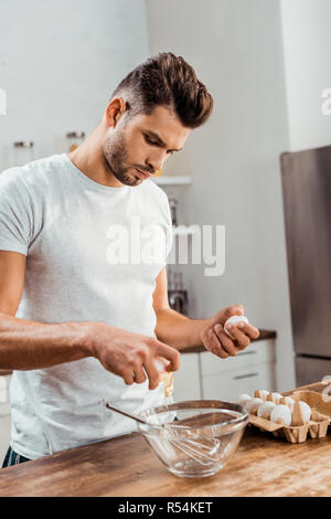 Beau jeune homme, la préparation d'omelette pour le petit déjeuner Banque D'Images