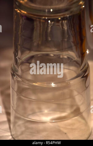 Détail de l'eau unique de verre, verres de l'eau sont à l'envers et dans le chaud shimmer macro shot golden glow Banque D'Images