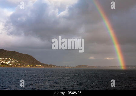 Arc-en-ciel sur Breidsundet, et le village de Leitebakk sur Godøya, Møre og Romsdal (Norvège) Banque D'Images