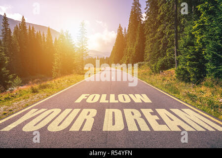 Suivez votre rêve texte écrit sur route dans les montagnes Banque D'Images
