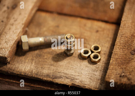 Vis et écrous sur une surface en bois Banque D'Images