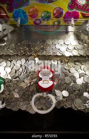 Dix pence 10p Pièces en attente de l'automne et sera gagné ( ou perdu et aller à l'arcade titulaire ) dans un coin pusher / pièces poussant jeu à un pier arcade fun house. UK. (98). Banque D'Images