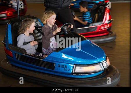 Deux jeunes filles / soeurs / Enfants / enfants âgés de six ans et huit ans ride la dodgem cars / bouclier avant voiture dans un parc d'attractions de la mer. Royaume-uni (104) Banque D'Images