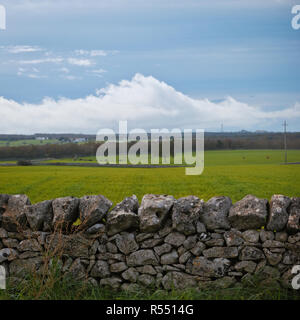 Scène de l'avant-plan de murs en pierre et ciel nuageux lointain sur les terres agricoles de la région des Pouilles. Banque D'Images