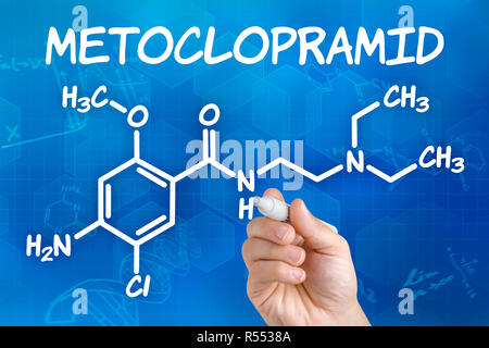 La main avec stylo chimique attire de la formule structurelle metoclopramide Banque D'Images