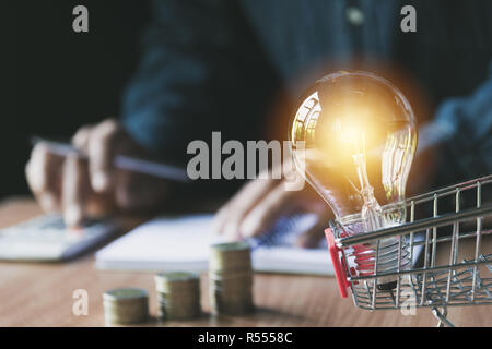 Pile de coin et ampoule dans le panier pour la comptabilité et concept d'entreprise. Banque D'Images