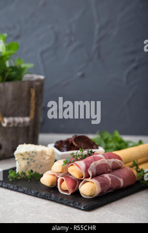 Apéritif avec prosciutto, jambon, fromage bleu et tomates séchées au soleil pour les vacances Banque D'Images