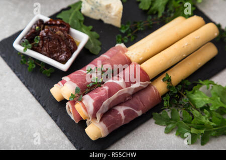 Apéritif avec prosciutto, jambon, fromage bleu et tomates séchées au soleil pour les vacances Banque D'Images