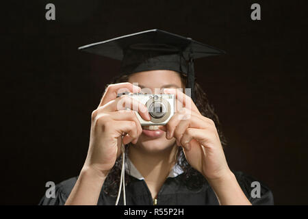 Female graduate taking a photograph Banque D'Images