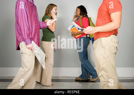 Quatre étudiants à marcher le long d'un corridor Banque D'Images