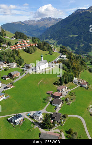 Autriche : le Barholomäus Airshot d'église au-dessus de Schruns tandis que le parapente dans la vallée du Montafon, Vorarlberg, Banque D'Images