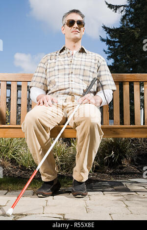 Un homme aveugle, assis sur un banc Banque D'Images