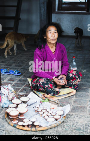 Katmandou, Népal - Avril 2015 : vieille femme vendant des bougies dans un temple bouddhiste de Swayambhunath. Orientation verticale. Banque D'Images