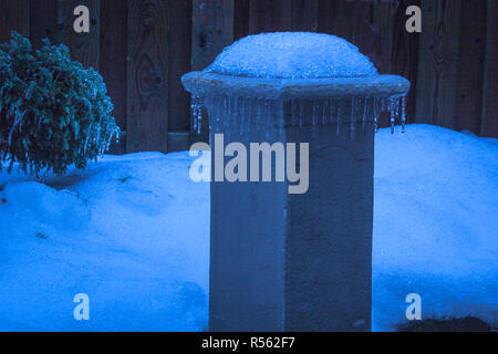 Rangée de icycles s'est formée sur le bord d'un socle de jardin en hiver. L'Ontario, Canada Banque D'Images