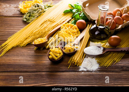 Table de cuisine pendant la cuisson avec les oeufs de poule et de farine et d'huile d'olive et basilic Banque D'Images