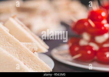 Petit sandwich cocktail avec des tomates sur une nappe noire Banque D'Images