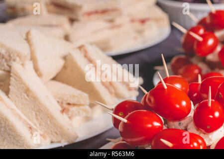 Petit sandwich cocktail avec des tomates sur une nappe noire Banque D'Images