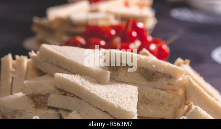 Petit sandwich cocktail avec des tomates sur une nappe noire Banque D'Images