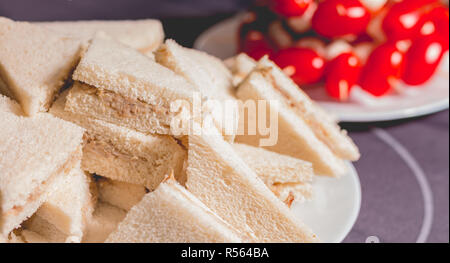 Petit sandwich cocktail avec des tomates sur une nappe noire Banque D'Images