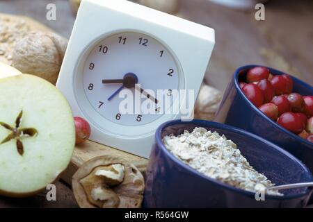 Petit-déjeuner sain - réveil, lait, le gruau, les canneberges, les noix, les pommes sur une table en bois Banque D'Images