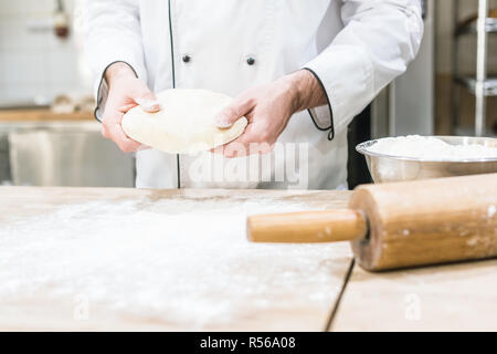 Baker holding pâte non cuite dans les mains Banque D'Images