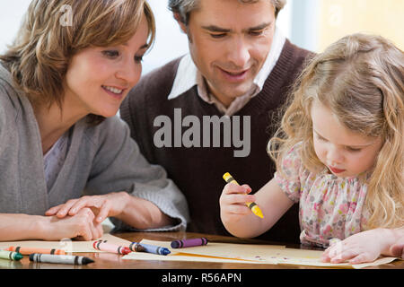 Les parents d'aider leur fille dessiner Banque D'Images