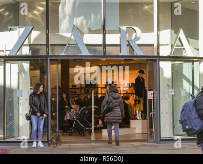 WINDSOR, ANGLETERRE - NOVEMBRE 2018 : grand panneau au-dessus de l'entrée d'une succursale de la chaîne de vêtements Zara en centre-ville de Windsor. Un client entre dans la Banque D'Images