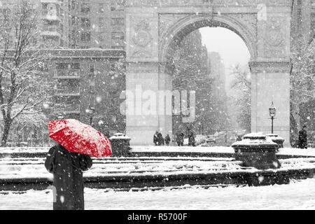 Personne de marcher seul avec parapluie rouge en noir et blanc scène d'hiver dans la région de Washington Square Park, New York City Banque D'Images