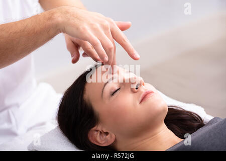 Close-up of a Young Woman Receiving Traitement Reiki thérapeute par Banque D'Images