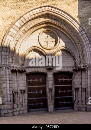 Belgique, Bruges, porte de bois sous une arche en pierre Banque D'Images