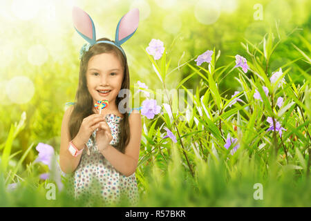 Petit enfant Cute asian girl with lollipop wearing Bunny Ears Banque D'Images