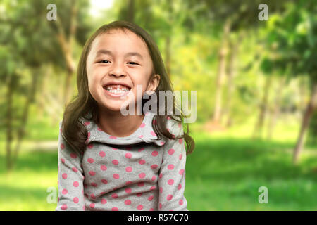 Drôle de sourire petite fille asiatique avec sa dent cassée Banque D'Images